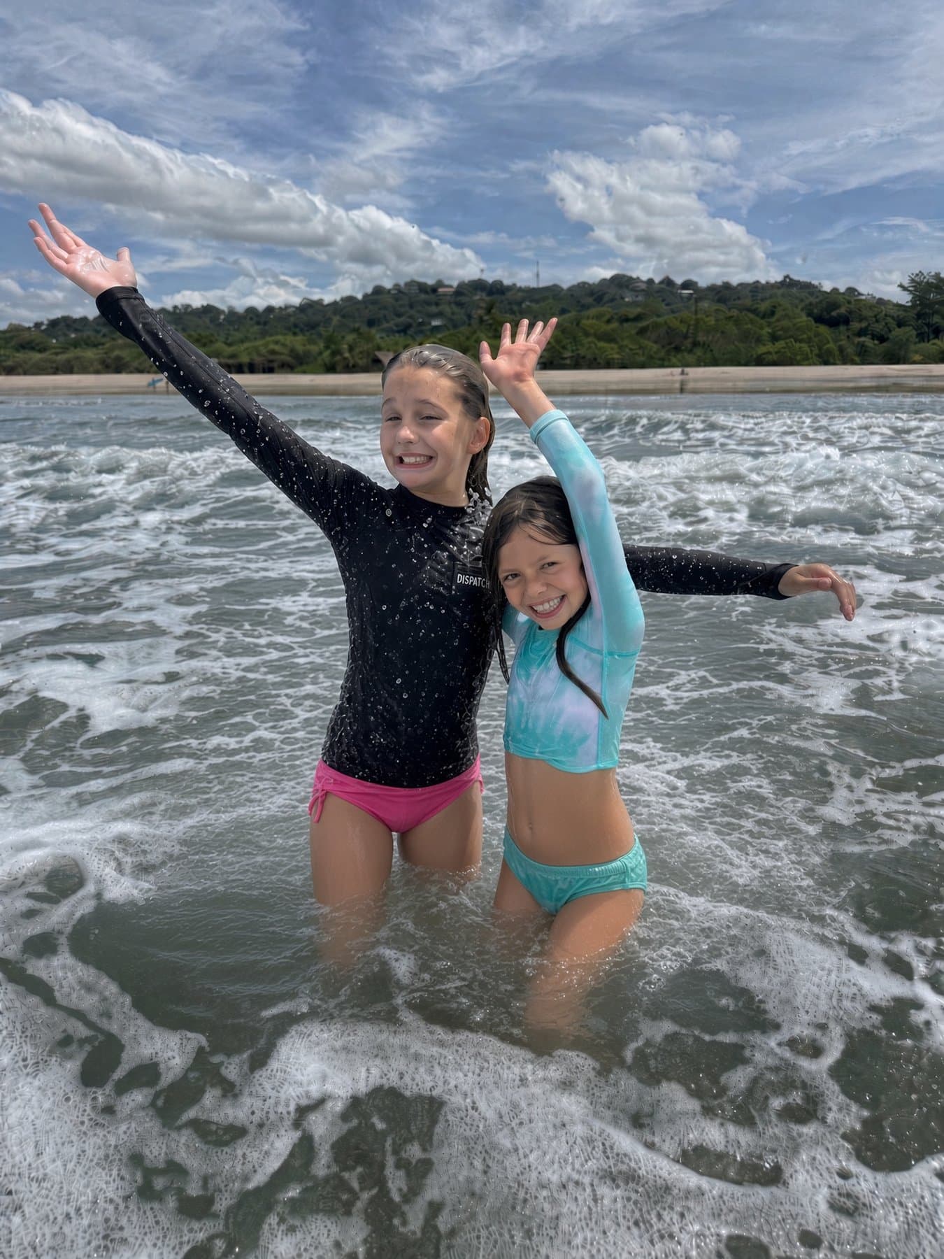 Two kids playing in the shorebreak after their lesson.